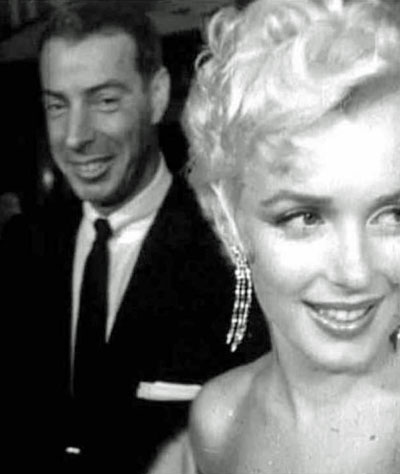 A woman dressed as Marilyn Monroe wearing earrings worn by Marilyn Monroe  in the film How to Marry a Millionaire which are part of the Famous and  Infamous exhibition which includes highlights